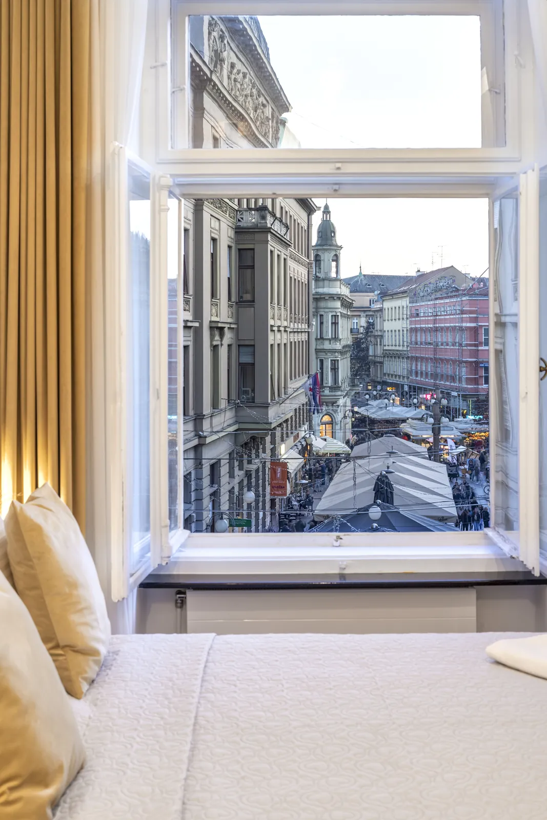 Pogled kroz prozor studio apartmana na Ilicu i krovove Donjeg grada
